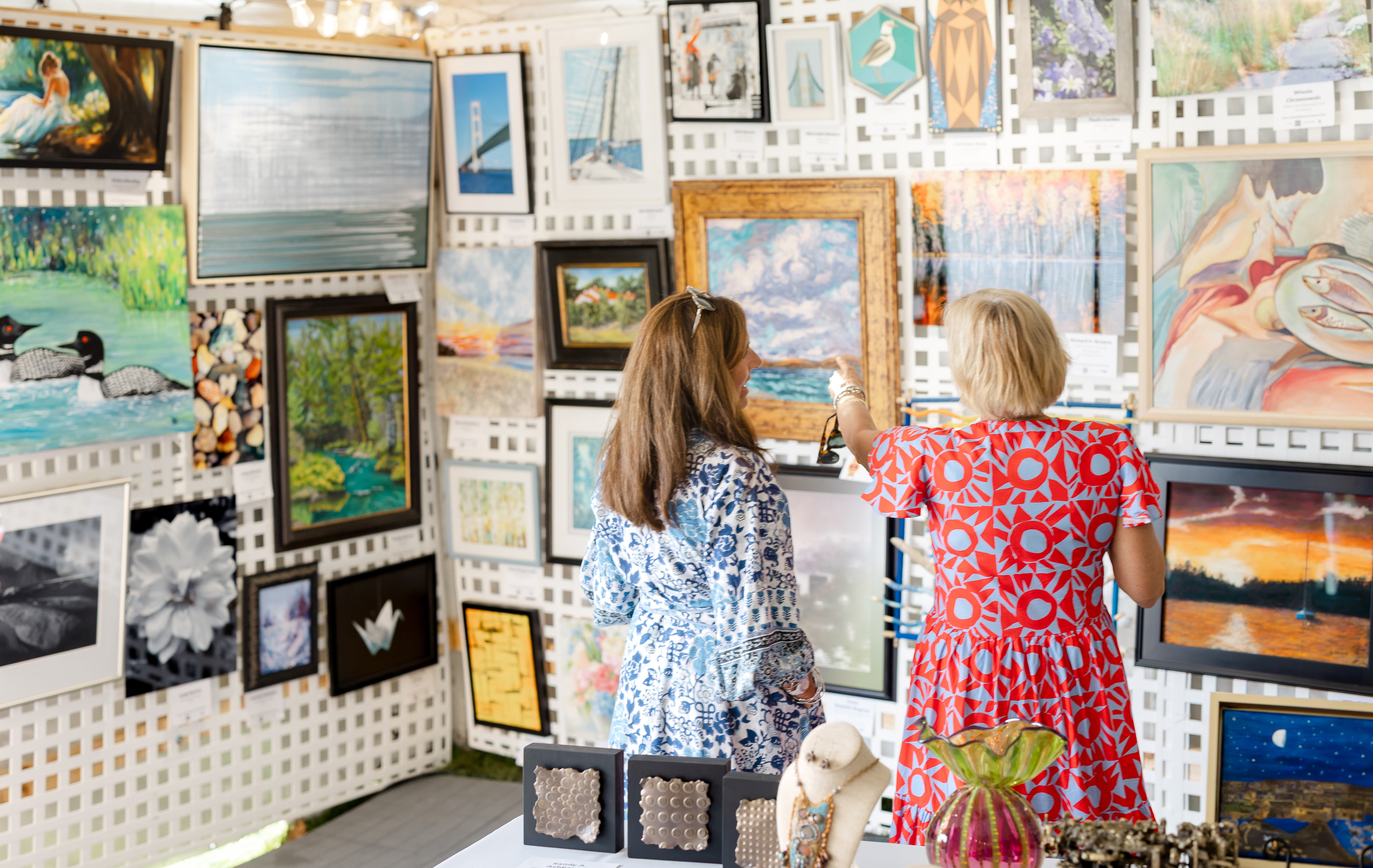 Two women standing looking at an art gallery wall