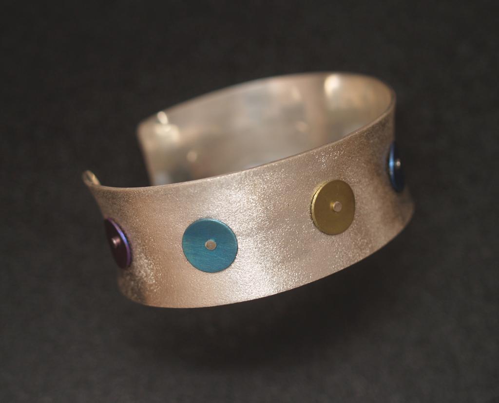 Anticlastic silver cuff with riveted niobium dots